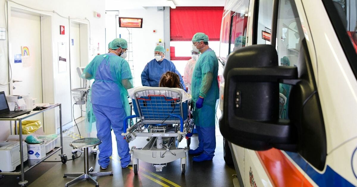 Medical workers wearing face masks and protective gear bring a patient on a stretcher suspected of having COVID-19 inside the new coronavirus intensive care unit of the Brescia Poliambulanza hospital in Lombardy, Italy, on March 17, 2020.