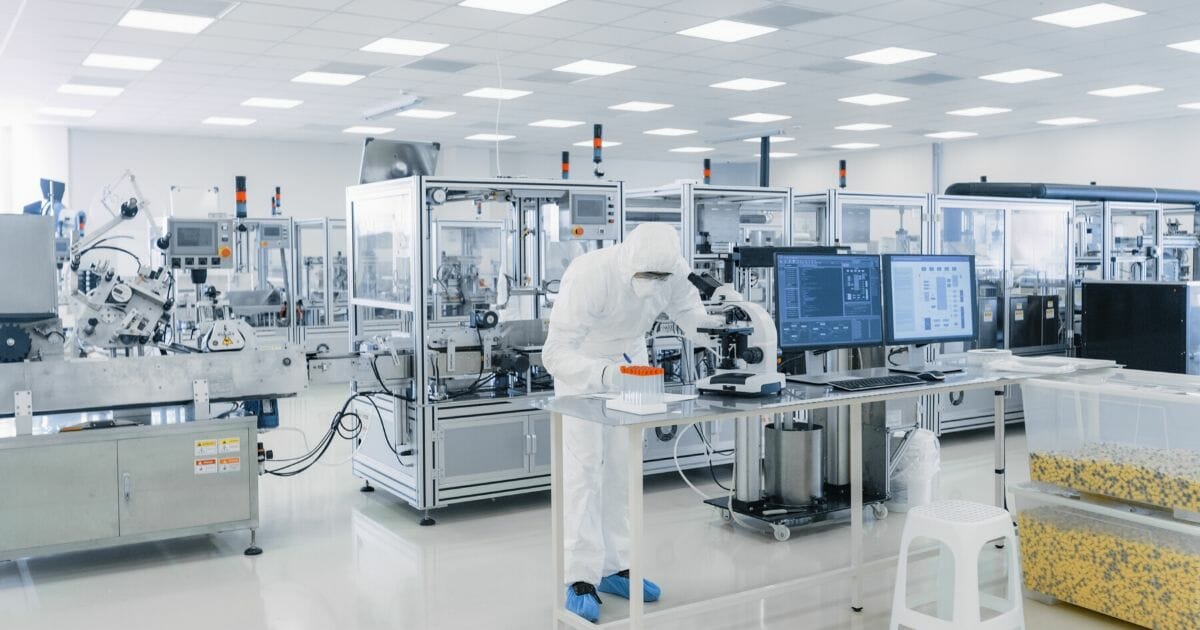 A sterile pharmaceutical manufacturing laboratory with scientists in protective gear.