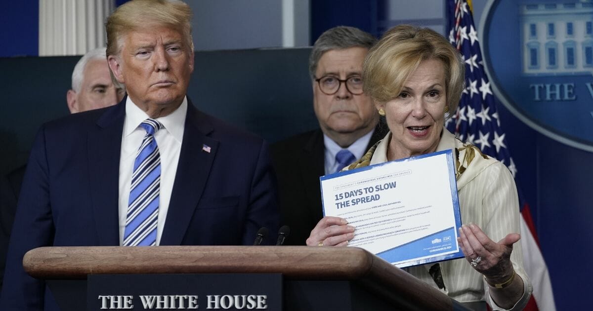 White House coronavirus response coordinator Deborah Birx holds up a CDC advisory as President Donald Trump and Attorney General William Barr listen at the daily coronavirus briefing at the White House on March 23, 2020.