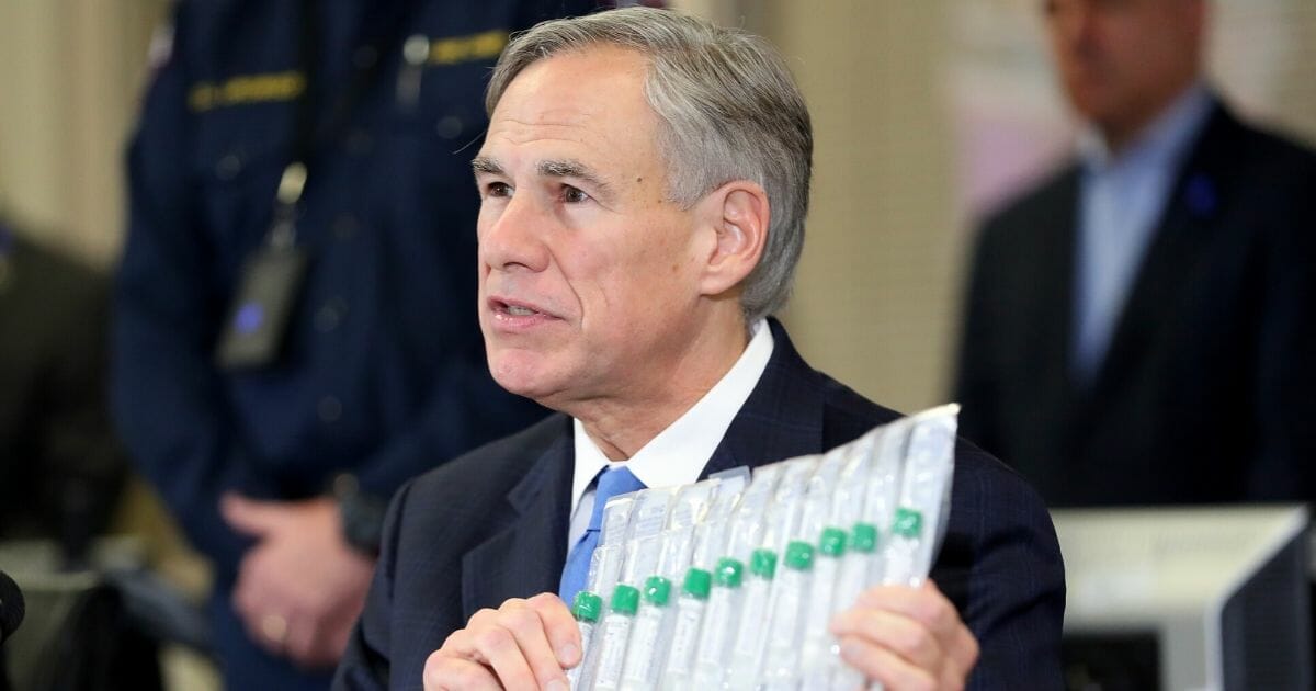 Texas Gov. Greg Abbott displays COVID-19 test collection vials as he addresses the media during a news conference held at Arlington Emergency Management on March 18, 2020, in Arlington, Texas.