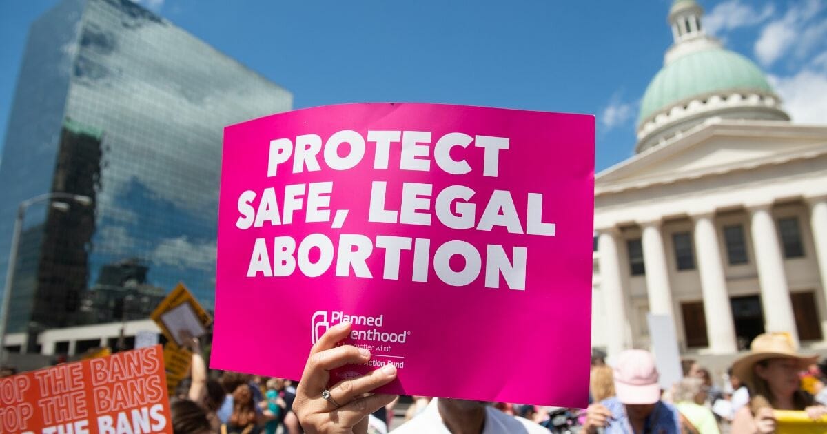 Protesters hold signs as they rally in support of Planned Parenthood near the Old Courthouse in St. Louis on May 30, 2019.
