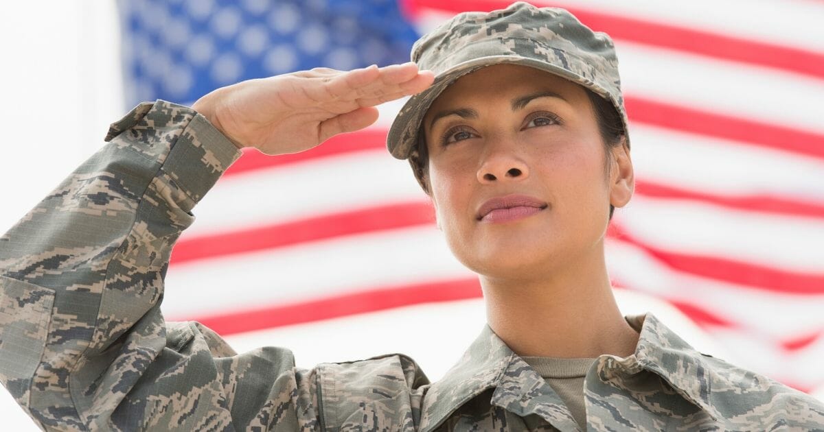 A female service member salutes in the stock image above.