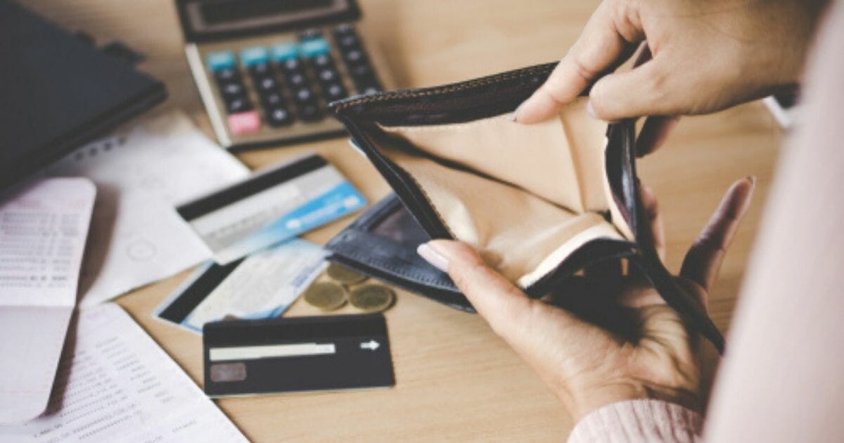 A woman is seen opening her wallet in the stock image above.