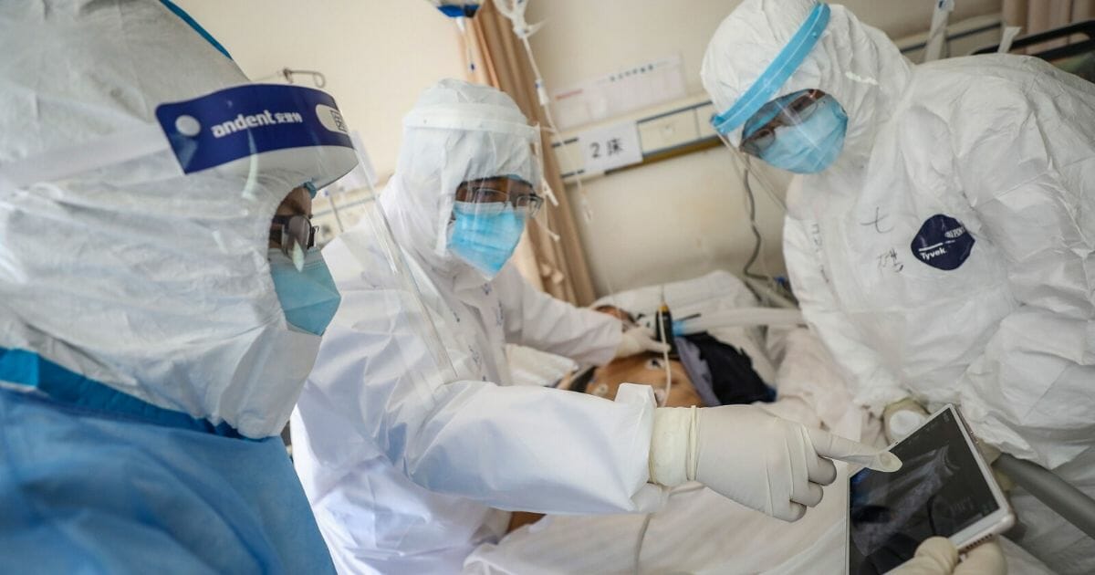 This photo taken on Feb. 16, 2020, shows a doctor looking at an image as he checks a patient who is infected by the coronavirus at the Wuhan Red Cross Hospital in Wuhan in China's central Hubei province.