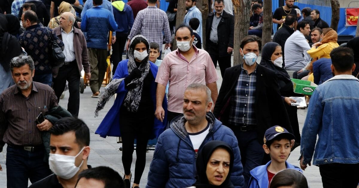 Iranians, some wearing protective masks, gather inside the capital city of Tehran's grand bazaar amid the COVID-19 coronavirus pandemic crisis on March 18, 2020.