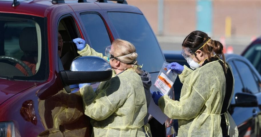 health care workers administering coronavirus tests in cars