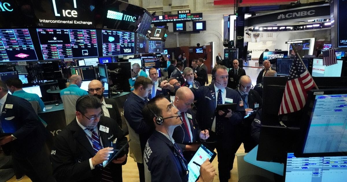 Traders work on the floor at the opening bell of the Dow Industrial Average at the New York Stock Exchange on March 18, 2020, in New York.