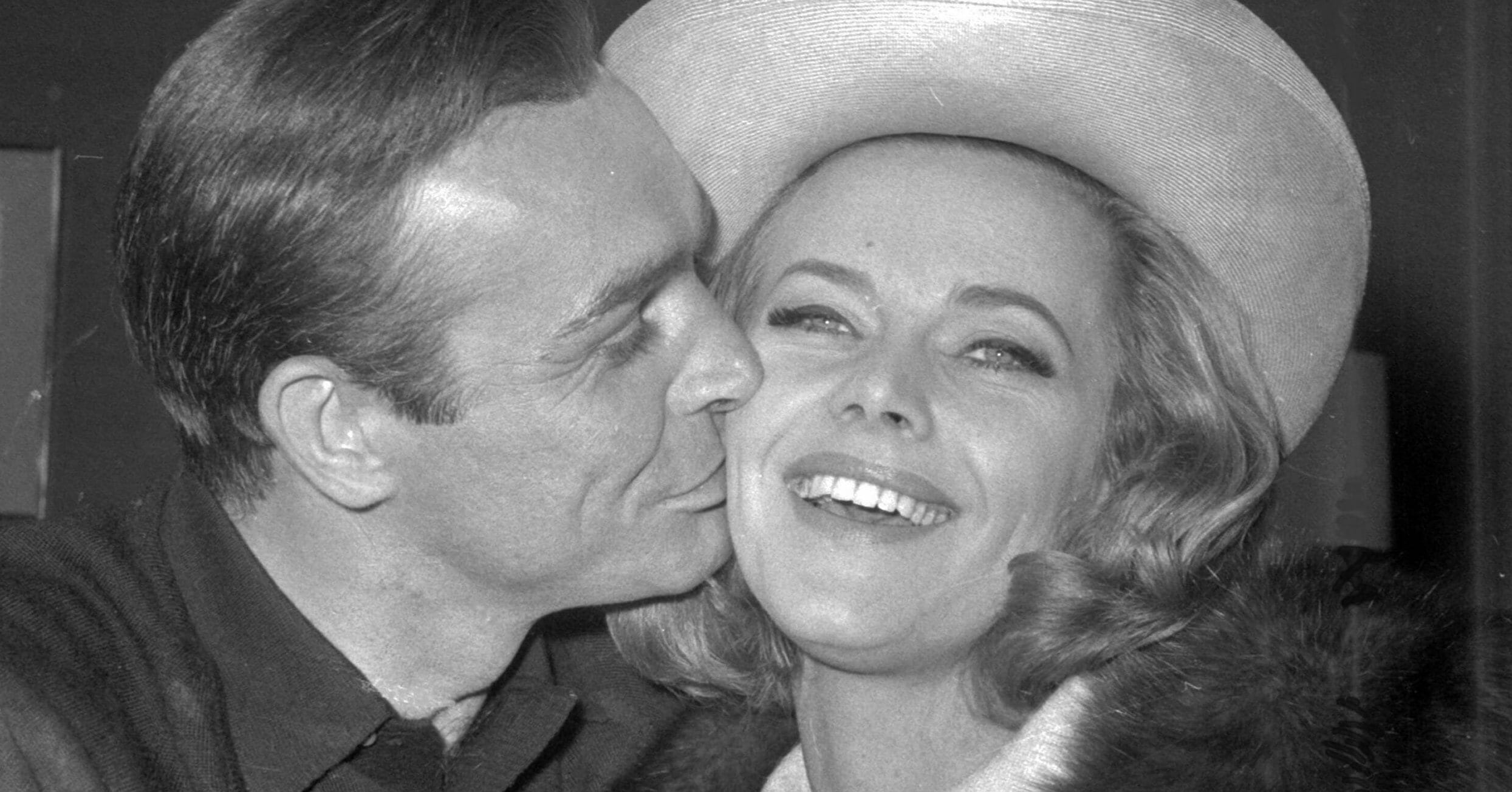 British actor Sean Connery kisses actress Honor Blackman during a party at Pinewood Film Studio, in Iver Heath, England, on March 25, 1964.