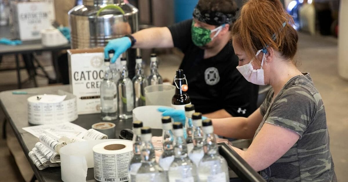 The team at Catoctin Creek Distilling Co. in Purcellville, Virginia, works on bottles of hand sanitizer.