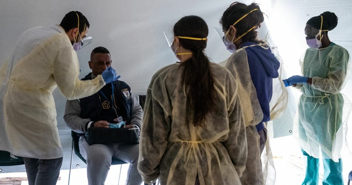 Doctors test staff with flu-like symptoms for the novel coronavirus in triage tents set up outside the main emergency department of St. Barnabas Hospital in the Bronx, New York, on March 24, 2020.
