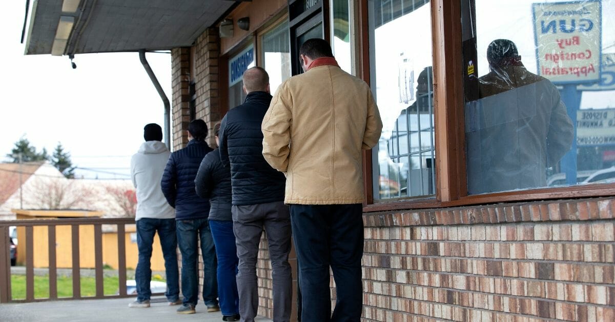 A line forms with people standing 6 feet apart outside Lynnwood Gun in Lynnwood, Washington, on April 2, 2020.