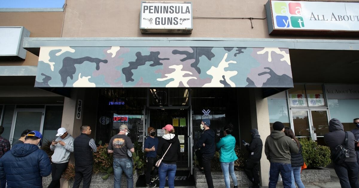 People wait in line to purchase guns and ammunition at Peninsula Guns and Tactical in San Bruno, California, on March 16, 2020.