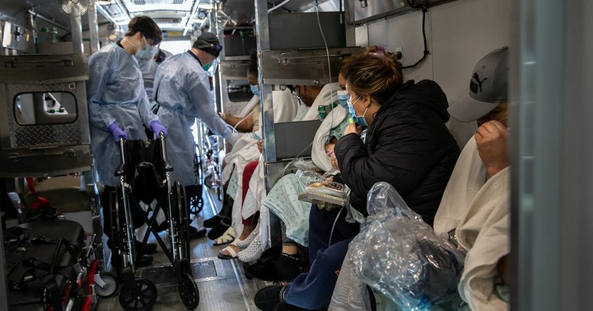 Medics wearing personal protective equipment unload COVID-19 patients arriving to the Montefiore Medical Center Moses Campus on April 7, 2020, in the Bronx borough of New York City.