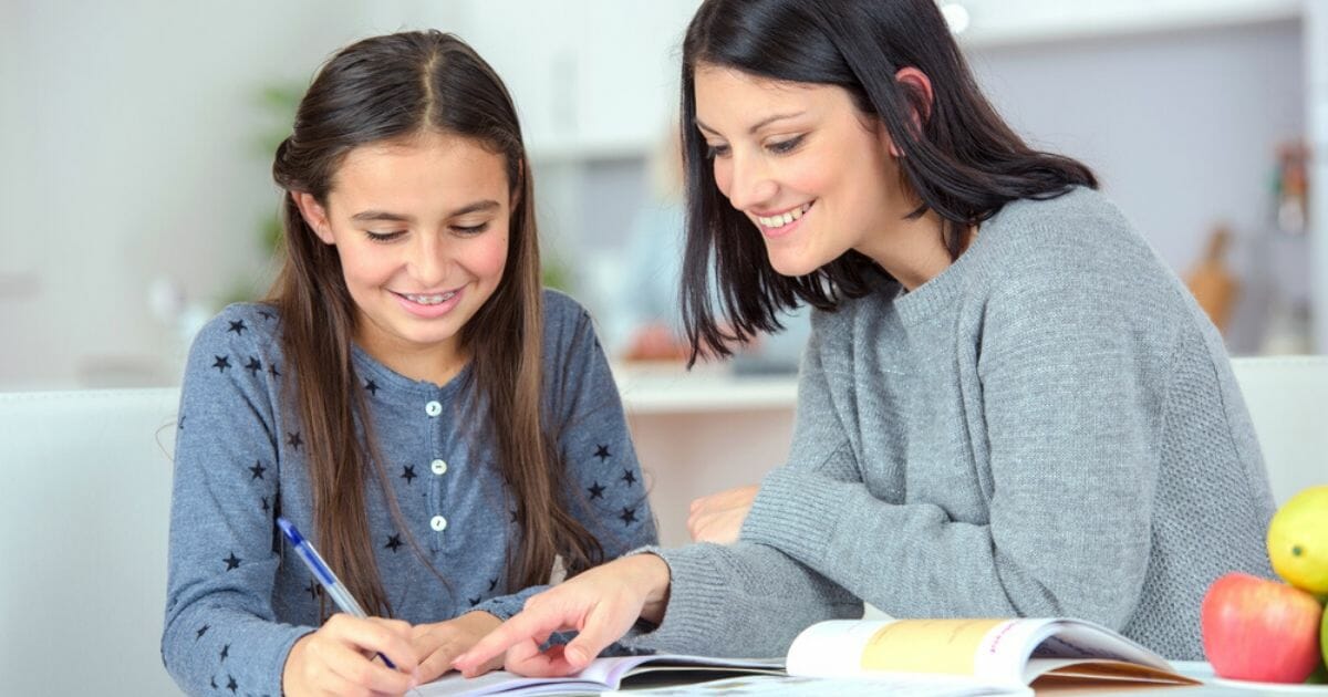 A mom helps her daughter with homework in the stock image above.