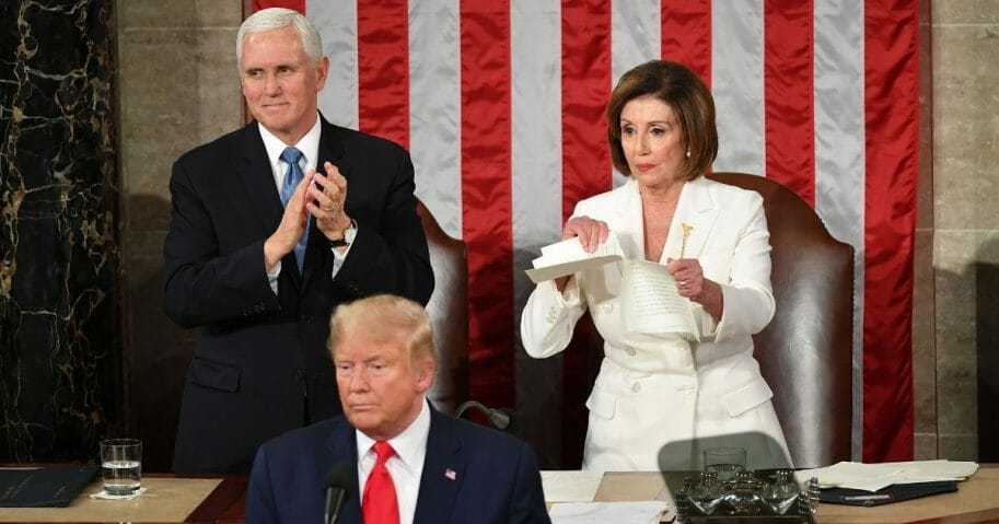 Vice President Mike Pence claps as Speaker of the House Nancy Pelosi rips up a copy of President Donald Trump's speech after he delivers the State of the Union address at the U.S. Capitol in Washington, D.C., on Feb. 4, 2020.