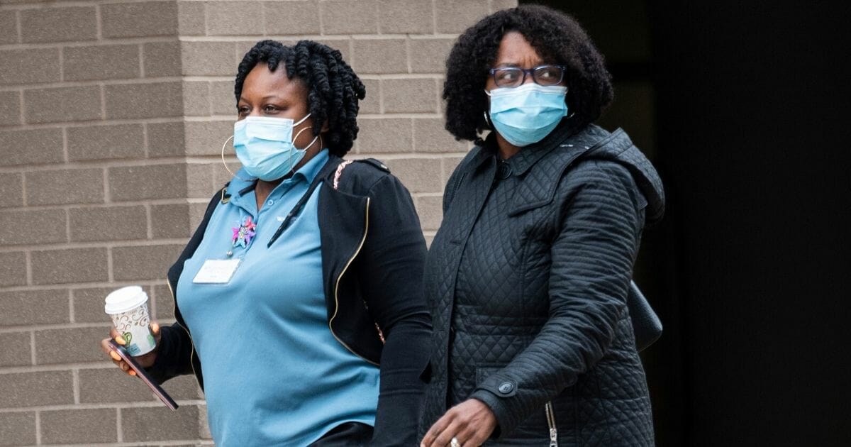 Medical workers wear masks as they walk back to the George Washington University Hospital in Washington on March 31, 2020.