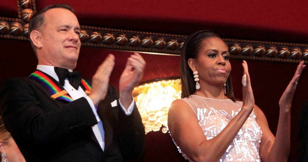 Actor/producer Tom Hanks, left, and then-first lady Michelle Obama attend the 27th Annual Kennedy Center Honors at John F. Kennedy Center for the Performing Arts on Dec. 7, 2014, in Washington, D.C.