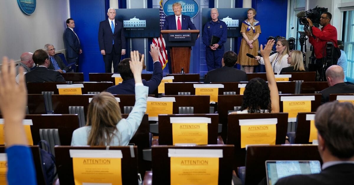 Members of the media raise their hands for questions at the daily coronavirus briefing at the White House on April 6, 2020.