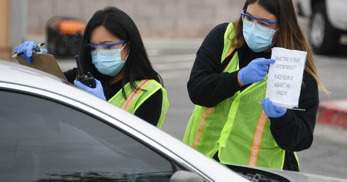 Health care administration students and volunteers at the University of Nevada, Las Vegas, check people in at a drive-up testing station for COVID-19 in the parking lot of UNLV Medicine on April 6, 2020, in Las Vegas.