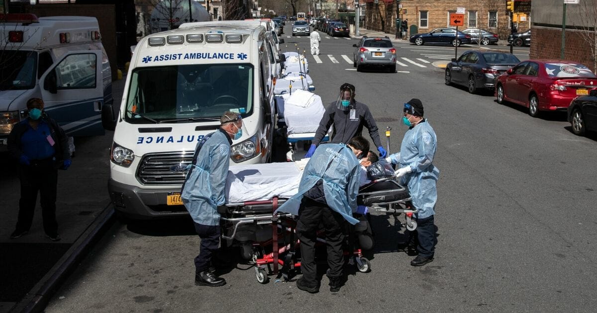 Medics and hospital workers prepare to lift a COVID-19 patient onto a hospital stretcher outside the Montefiore Medical Center Moses Campus on April 7, 2020, in the Bronx borough of New York City.