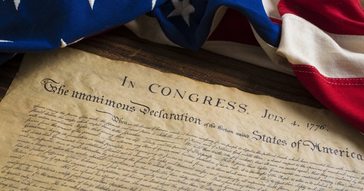 Stock image of the Declaration of Independence sitting on a vintage flag.