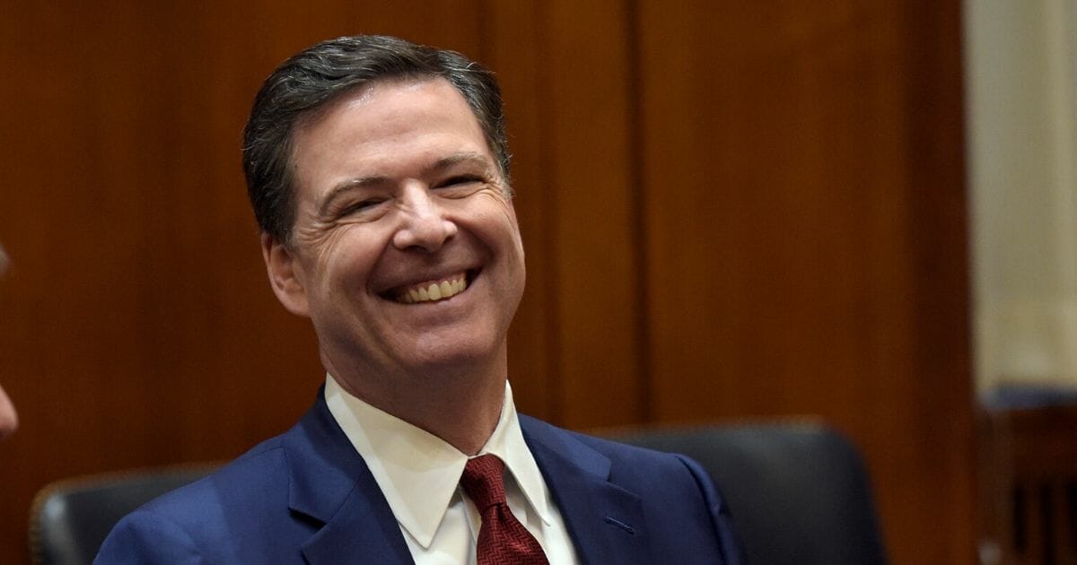 Then-FBI Director James Comey laughs in a February 2017 photo taken before he met with then-Attorney General Jeff Sessions in Washington.