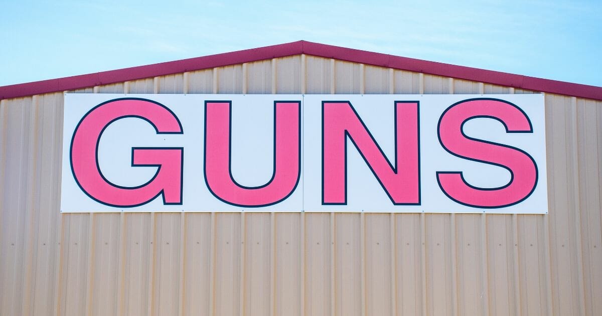 A "Guns" sign on the side of a gun store doesn't mince words about the goods being sold.