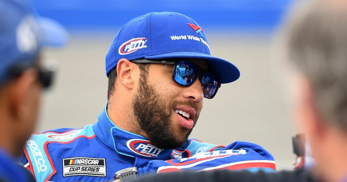 Bubba Wallace, driver of the #43 Victory Junction Chevrolet, stands by his car during qualifying for the NASCAR Cup Series Auto Club 400 at Auto Club Speedway on Feb. 29, 2020 in Fontana, California.