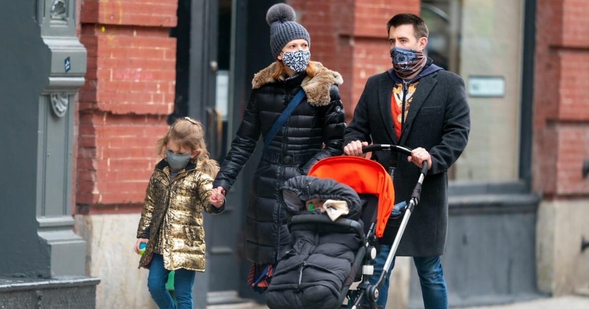 A family wearing protective face masks are seen in SoHo during the coronavirus pandemic on April 23, 2020, in New York City.