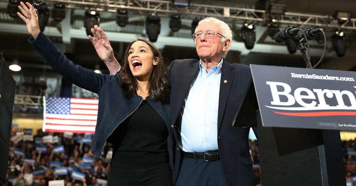 New York Rep. Alexandria Ocasio-Cortez and Vermont Sen. Bernie Sanders stand together at the Whittemore Center Arena on Feb. 10, 2020, in Durham, New Hampshire.