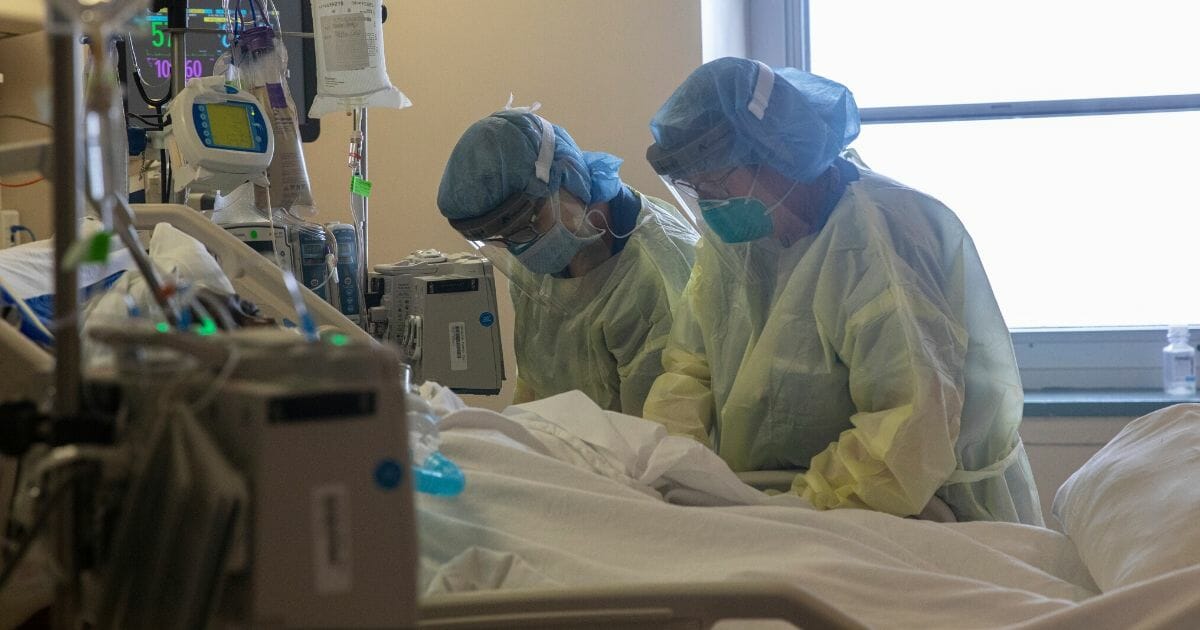 Two nurses assess the vital signs of a COVID-19 patient using a ventilator on the ICU floor at the Veterans Affairs Medical Center on April 21, 2020, in the Brooklyn borough of New York City.