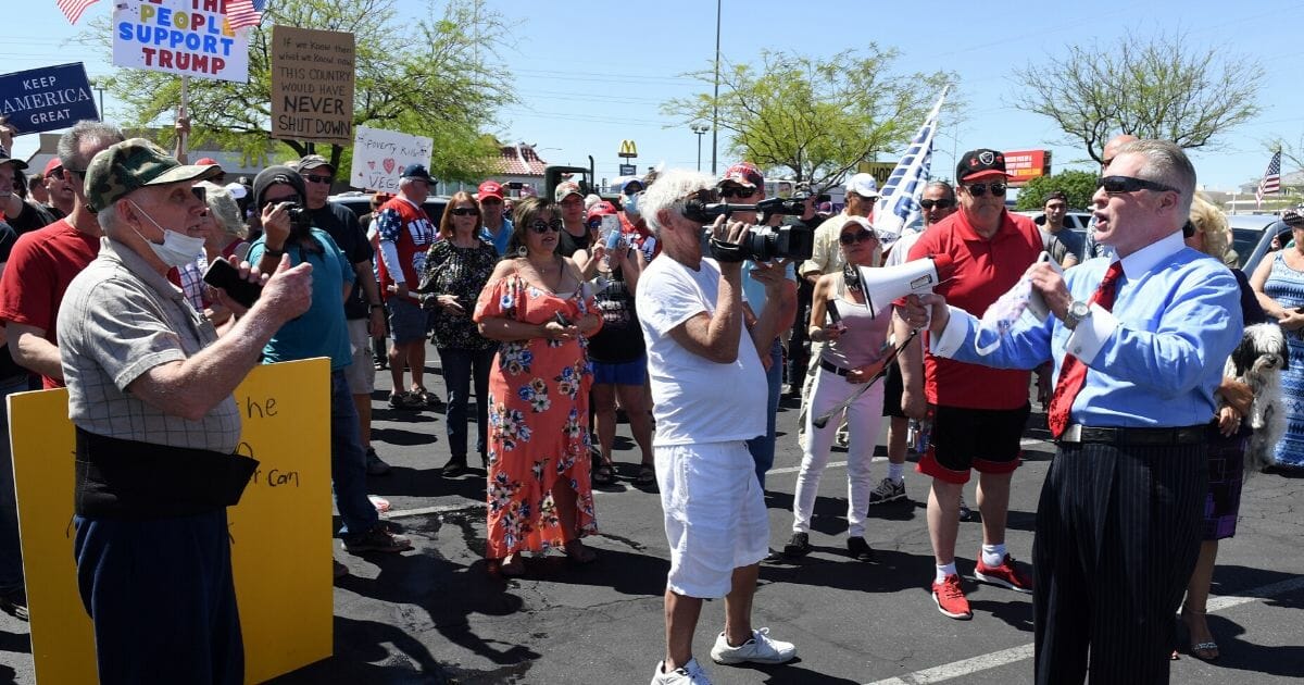 Conservative radio talk show host Wayne Allyn Root, right, speaks to supporters before hosting a protest caravan on the Las Vegas Strip to demand the reopening of the Nevada economy, hit hard by coronavirus-related closures, on April 24, 2020, in Las Vegas, Nevada.