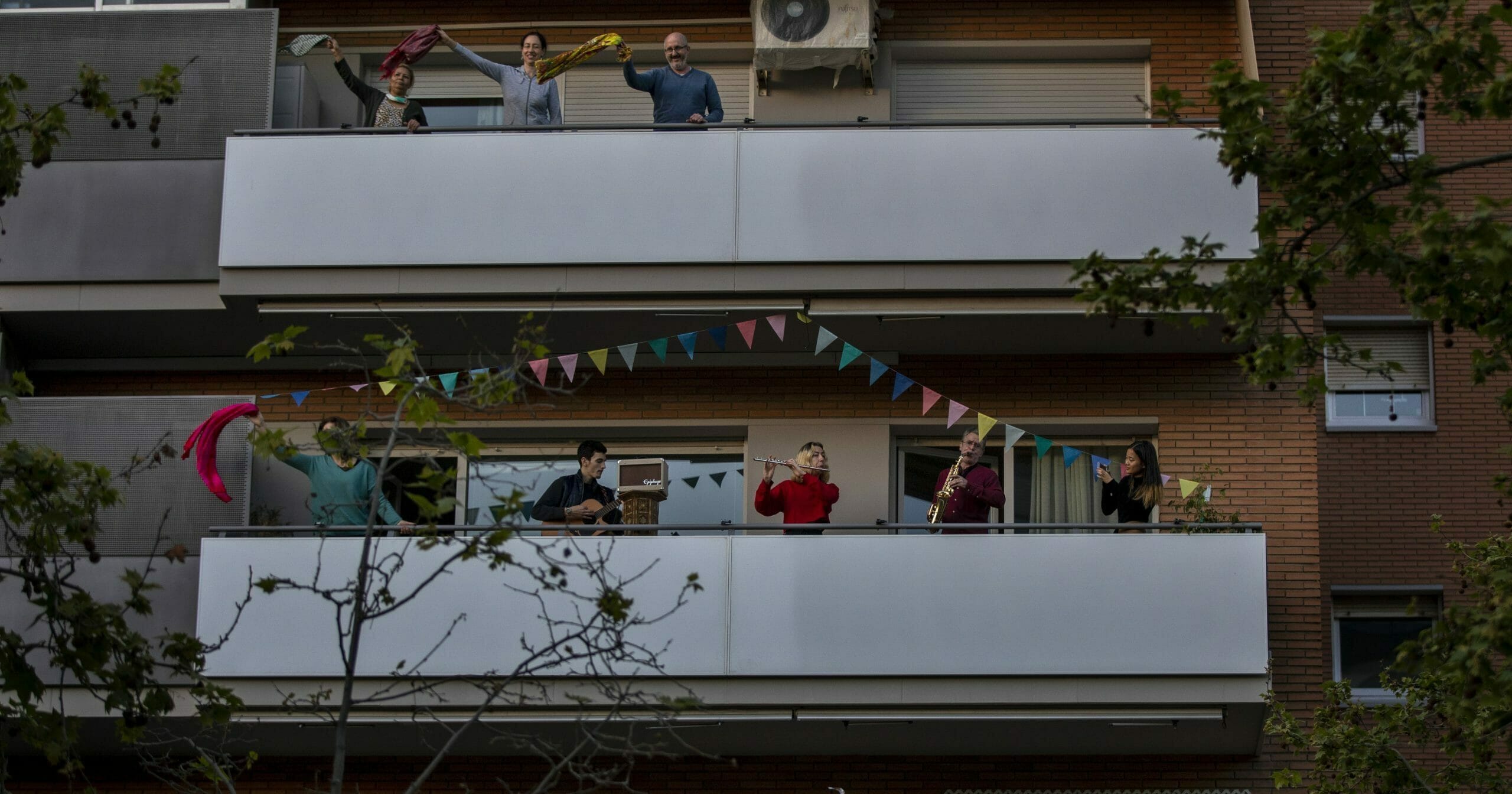People play instruments as others dance on their balconies in support of the medical staff that are working on the COVID-19 virus outbreak in Barcelona, Spain, on April 5, 2020.