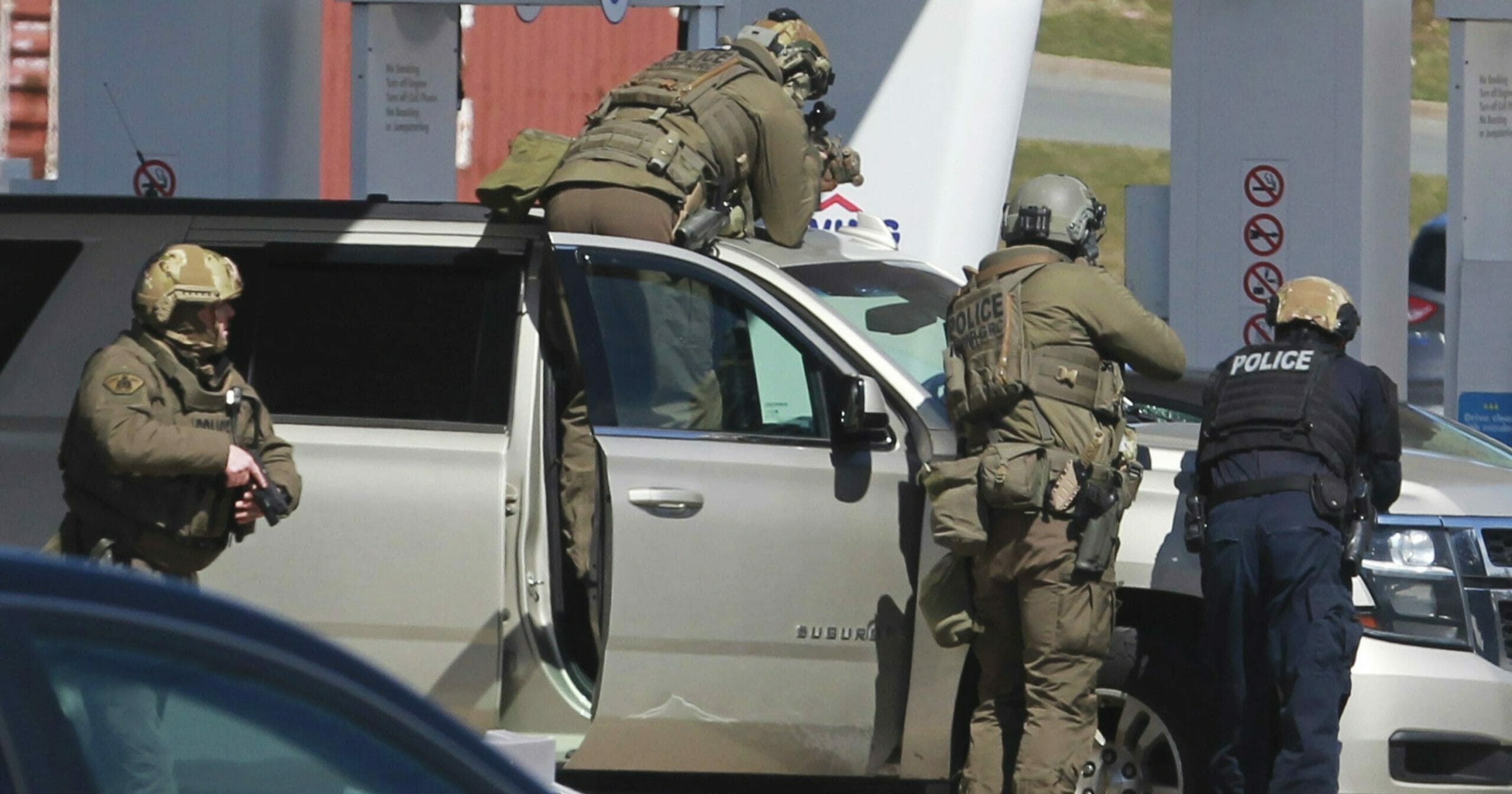 Royal Canadian Mounted Police officers surround a suspect at a gas station in Enfield, Nova Scotia, on April 19, 2020.