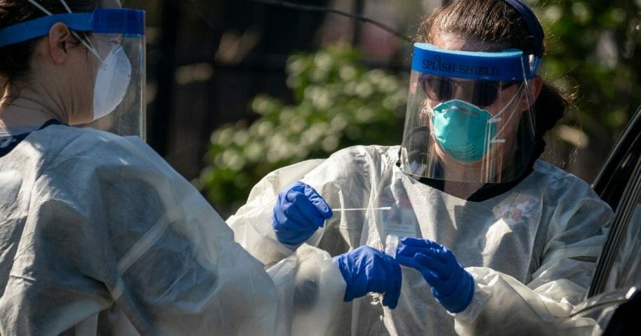 Medical professionals from Children's National Hospital administer a coronavirus test at a drive-thru testing site for children age 22 and under at Trinity University on April 2, 2020, in Washington, D.C.