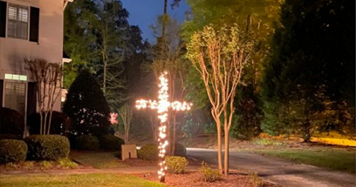 A cross illuminated with Christmas lights.