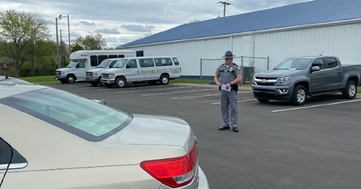 A Kentucky State Police trooper is seen in the parking lot of Maryville Baptist Church in Louisville, Kentucky, on Sunday.