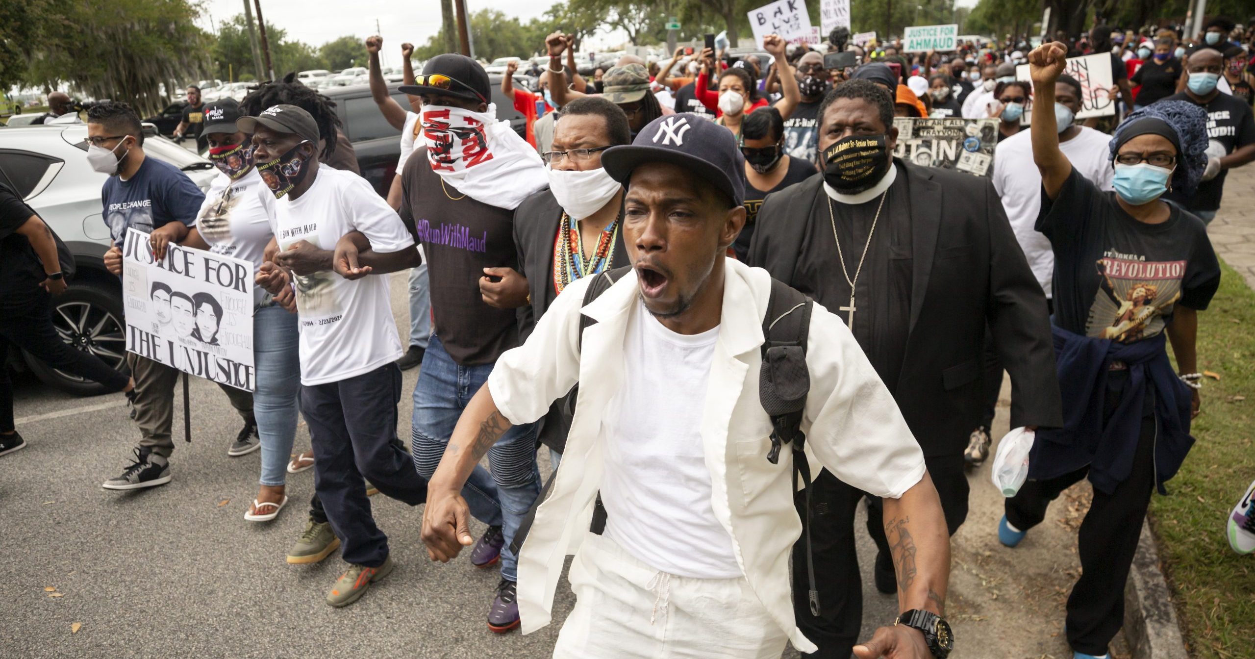 Malik Muhammad, center, joins a group of people marching from the Glynn County Courthouse in downtown to a police station after a rally to protest the shooting of Ahmaud Arbery on May 16, 2020, in Brunswick, Georgia.