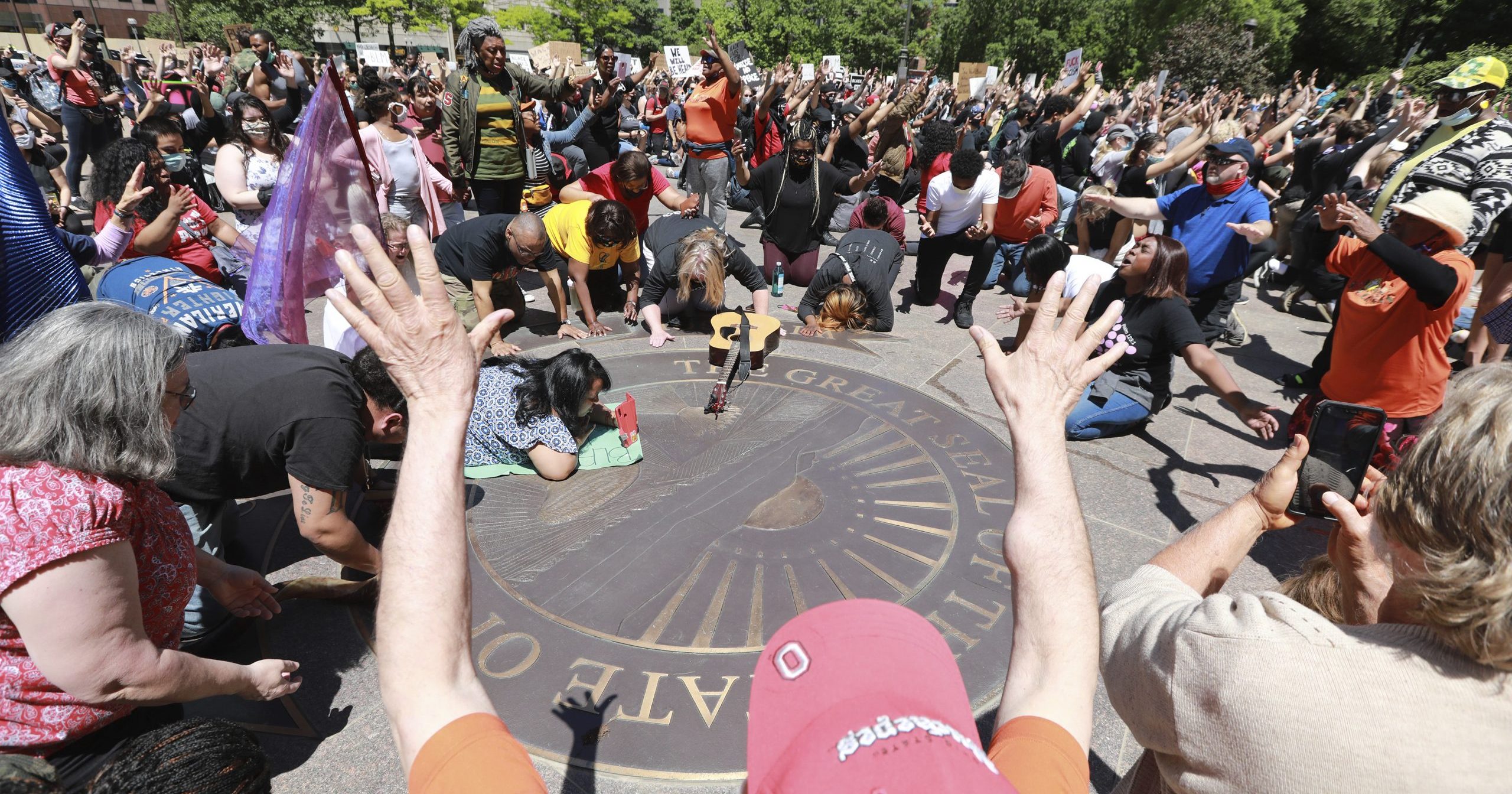Members of the Shiloh Christian Center pray on the west lawn of the Ohio Statehouse on May 31, 2020, as crowds gather for a peaceful protest over the death of George Floyd, a black man who was killed in police custody in Minneapolis on May 25.