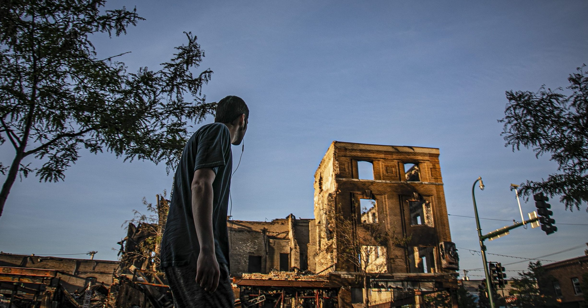 A man walks on Lake Street while looking at businesses destroyed during riots over the death of George Floyd on Sunday May 31, 2020, in Minneapolis. Floyd died after being restrained by Minneapolis police officers on May 25.
