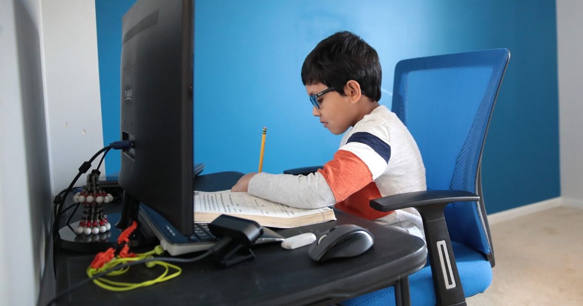Seven-year-old Hamza Haqqani, a second-grader at Al-Huda Academy in Illinois, uses a computer to participate in an E-learning class with his teacher and classmates from his home in Bartlett on May 1, 2020.