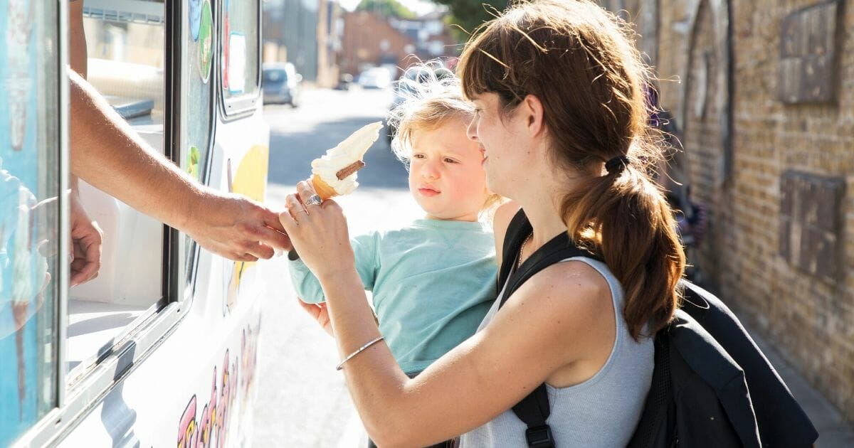 An ice cream seller gives ice cream to a mother and her toddler in the stock image above.