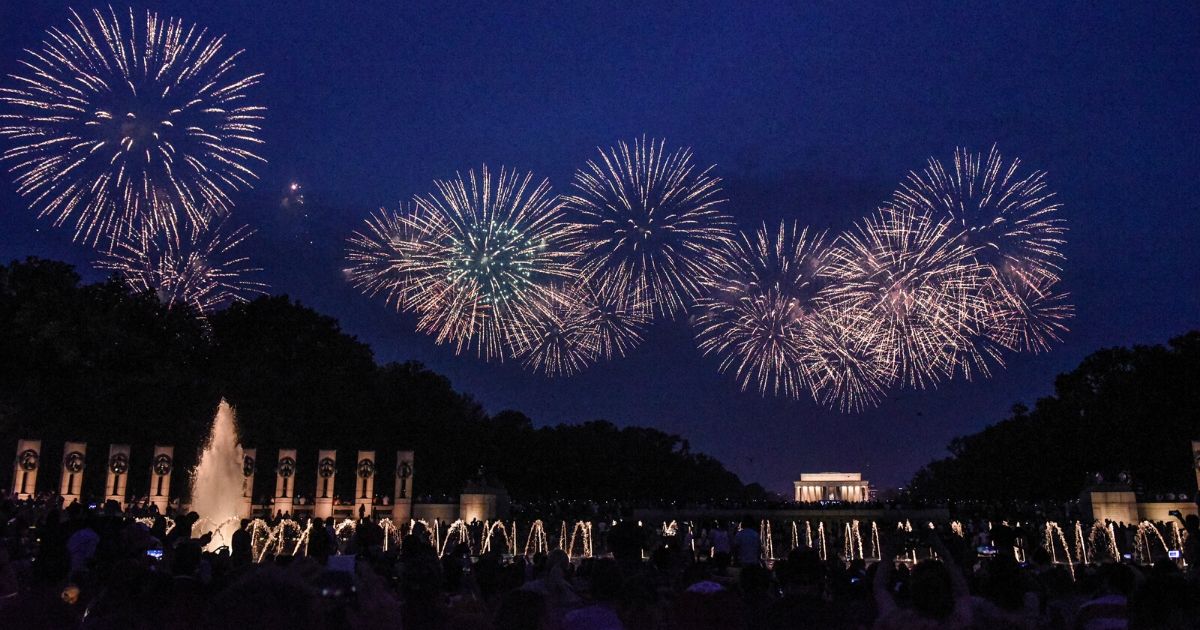 People watch the fireworks display on the National Mall during Fourth of July festivities on July 4, 2019, in Washington, D.C.