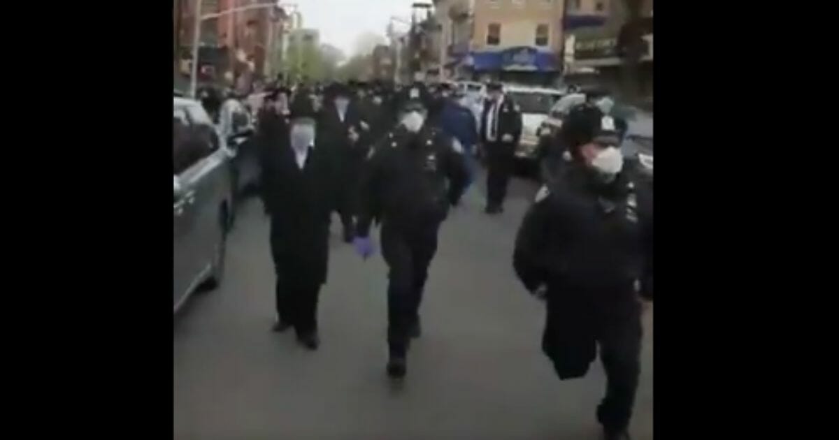 A video circulating on social media shows New York City Police Department officers breaking up a crowded funeral procession on Thursday, two days after Mayor Bill de Blasio said he had instructed the NYPD summons or arrest people gathering in large groups.