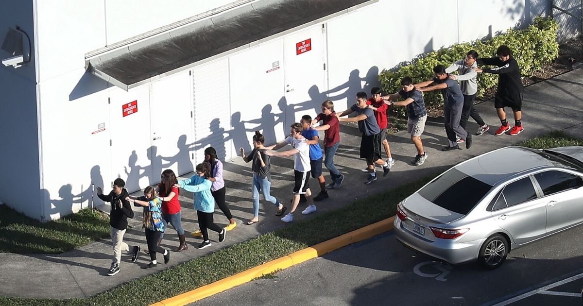 People are brought out of the Marjory Stoneman Douglas High School after a shooting at the school on Feb. 14, 2018, in Parkland, Florida.