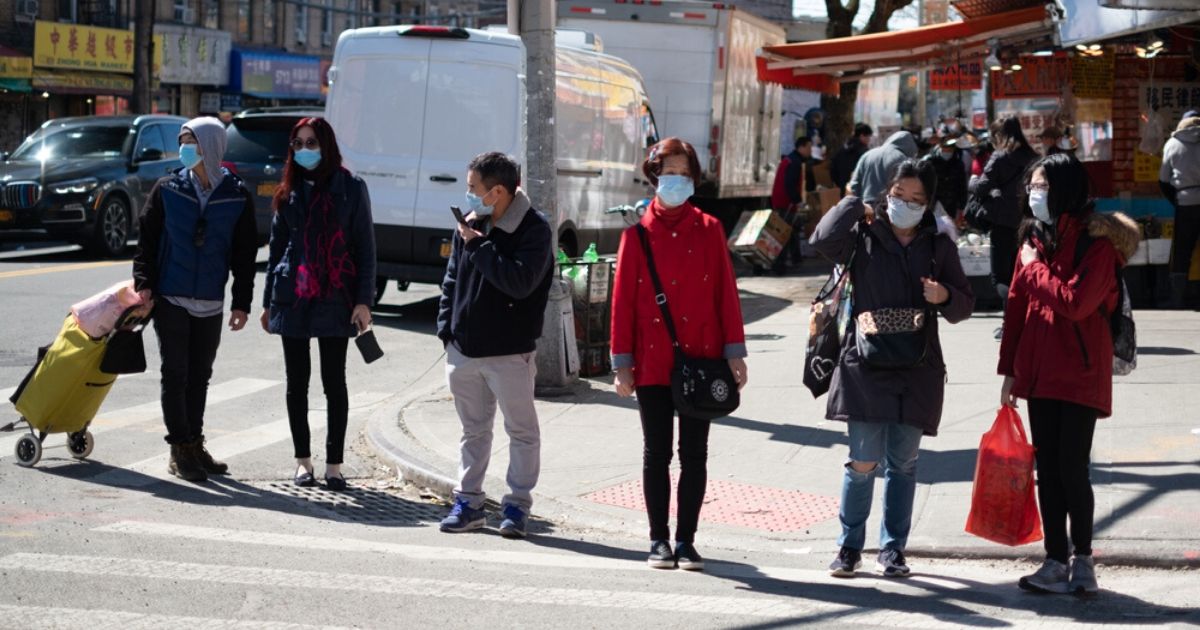 People wear masks on a New York City street in the stock image above.