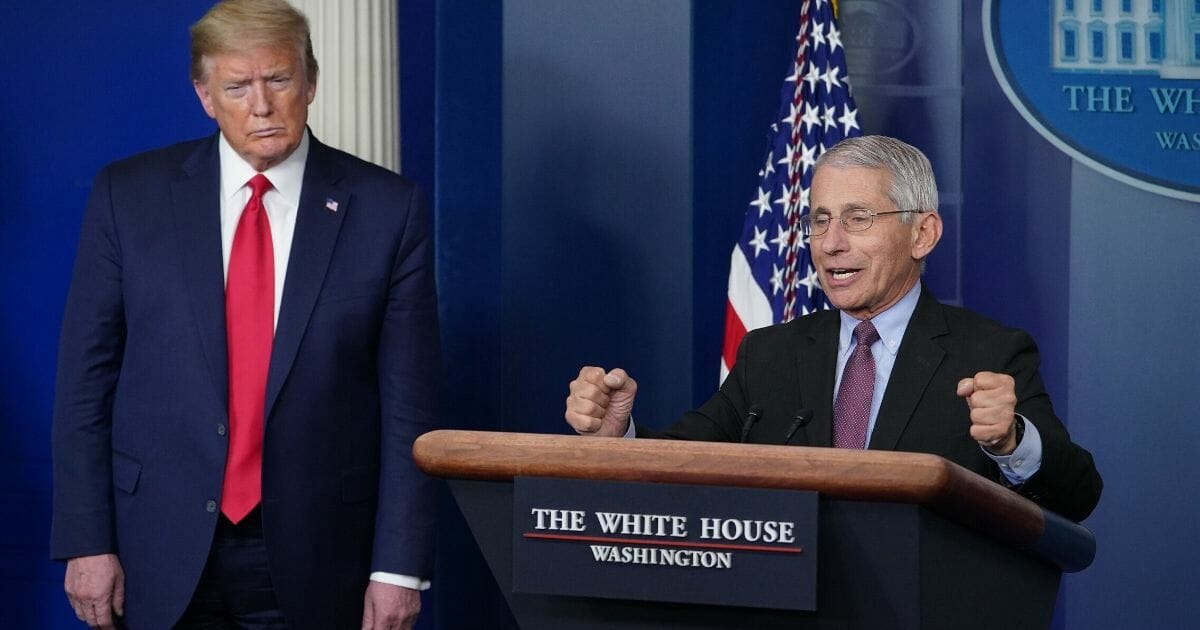 Dr. Anthony Fauci, director of the National Institute of Allergy and Infectious Diseases, is flanked by President Donald Trump as he speaks during the daily briefing on the coronavirus at the White House on April 22, 2020.
