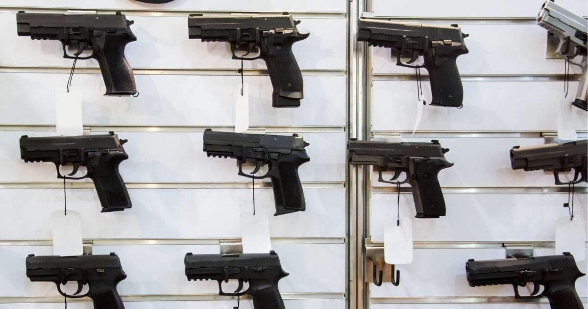 Handguns displayed on a wall for sale.