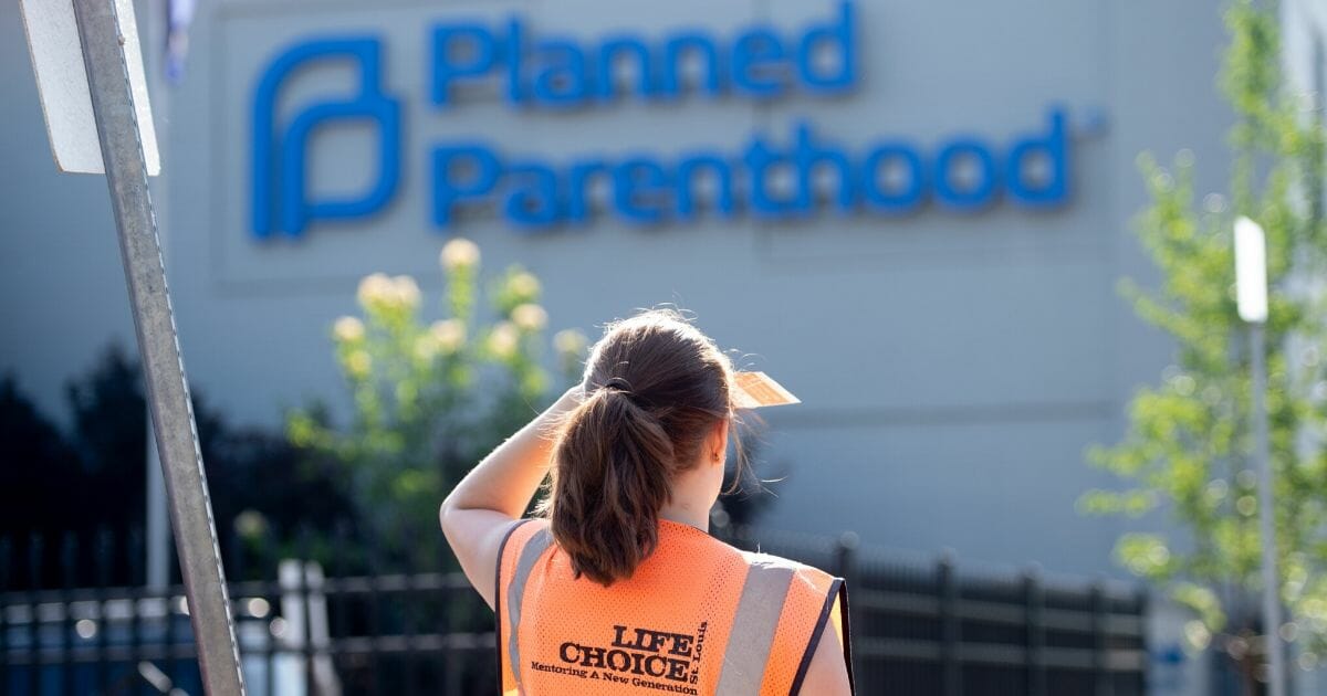 A sidewalk counselor with the pro-life group Coalition For Life stands outside the Planned Parenthood Reproductive Health Services Center in St. Louis in May 2019.