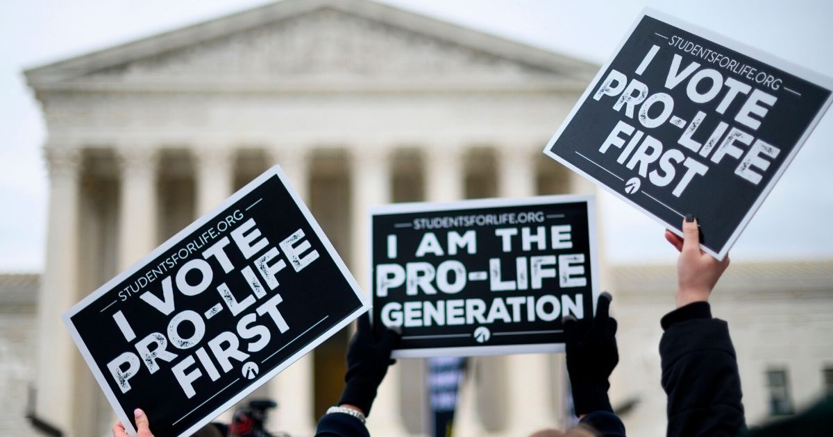 Pro-life advocates hold signs as they stand in front of the Supreme Court while participating in the 47th annual March For Life in Washington, D.C., on Jan. 24, 2020.